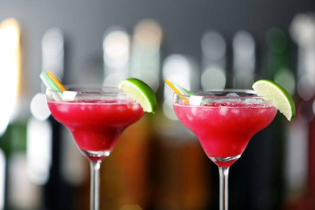 Glasses of delicious strawberry cocktail on blurred background