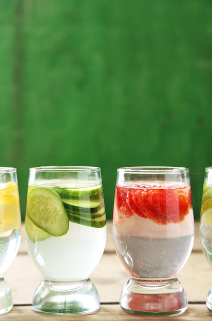 Photo glasses of different home made freshness healthy vitaminfortified water on wooden table