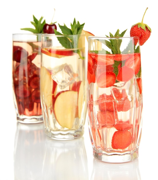 Glasses of fruit drinks with ice cubes isolated on white