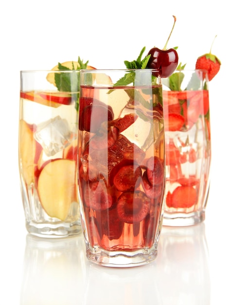 Glasses of fruit drinks with ice cubes isolated on white