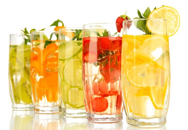 Glasses of fruit drinks with ice cubes isolated on white