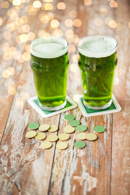 glasses of green beer and gold coins on table