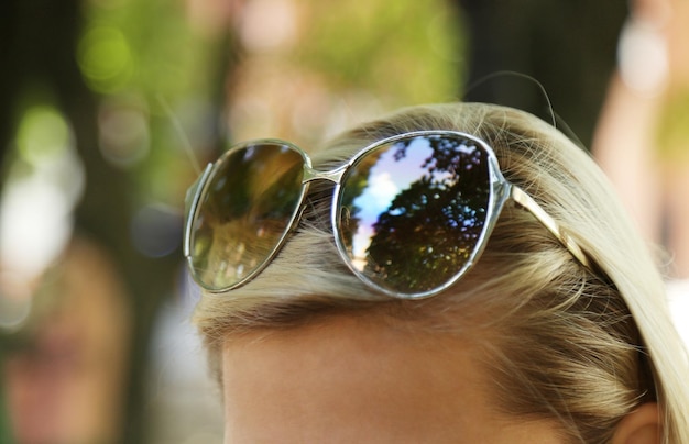 Glasses on head of girl on nature background