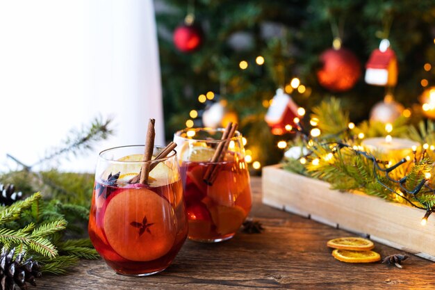 Photo glasses of hot mulled wine with fresh fruit apples and oranges traditional winter drink