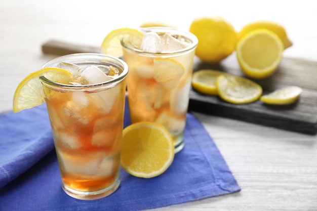 Glasses of iced tea with lemon slices on blue napkin