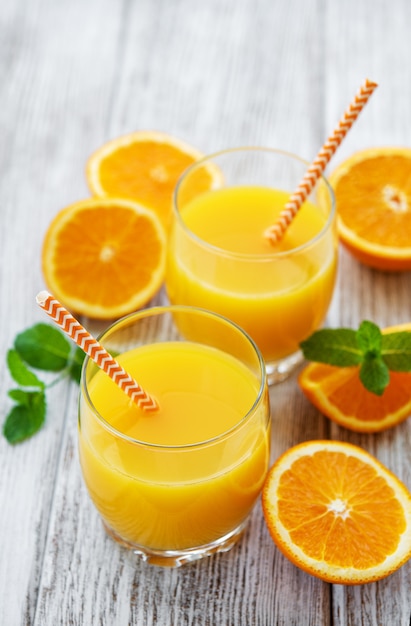 Glasses of juice and orange fruits