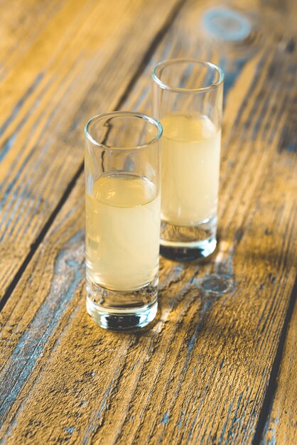 Glasses of limoncello on a wooden table