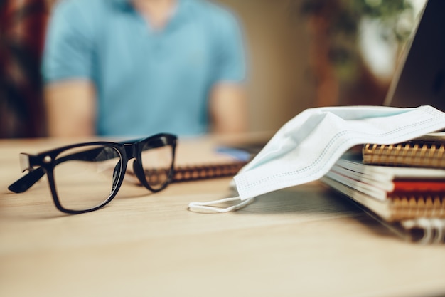 Glasses and medical mask on the table