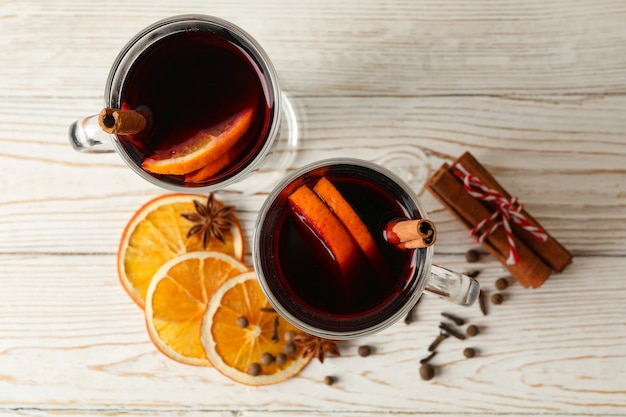 Glasses of mulled wine on white wooden background