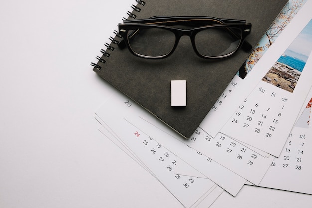 Glasses on notebook and calendars