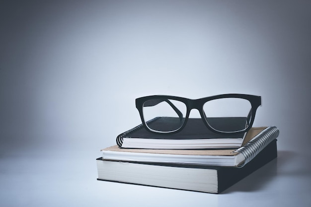 Glasses on notebook in white background.