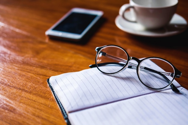 Glasses on notebooks, coffee cups on desks