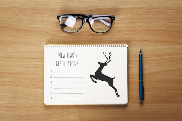 Glasses, notepad with pen lying on the table