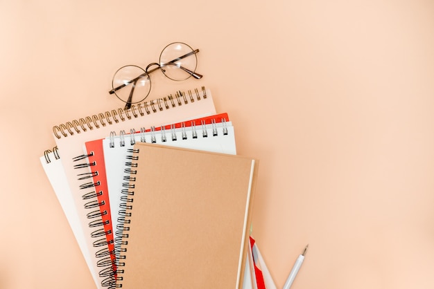 glasses and notepads  on a beige abstract background