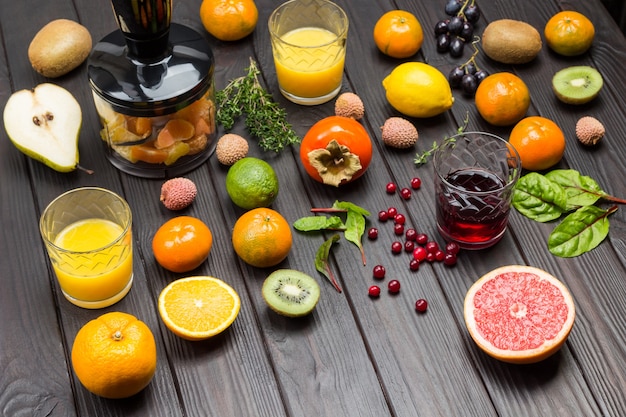 Фото Стаканы апельсинового и грейпфрутового сока с тропическими фруктами