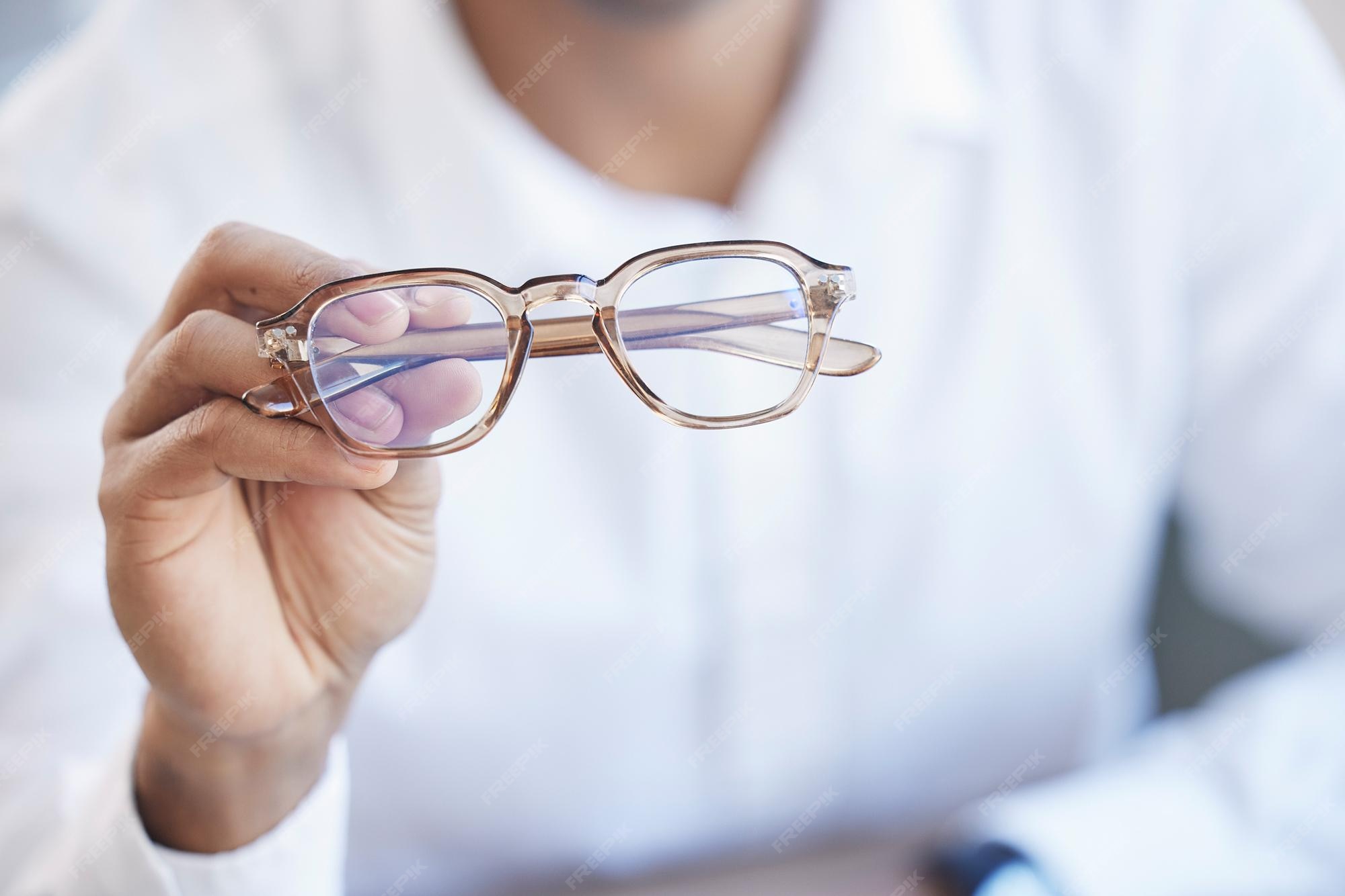 Premium Photo Glasses optometry and hand of optometrist holding