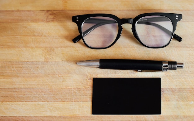 Glasses pen and notebook on a desk in empty office for abstract background business and vision Eye sight ideas and planner or journal on wooden table for reading and creative writing mockup space