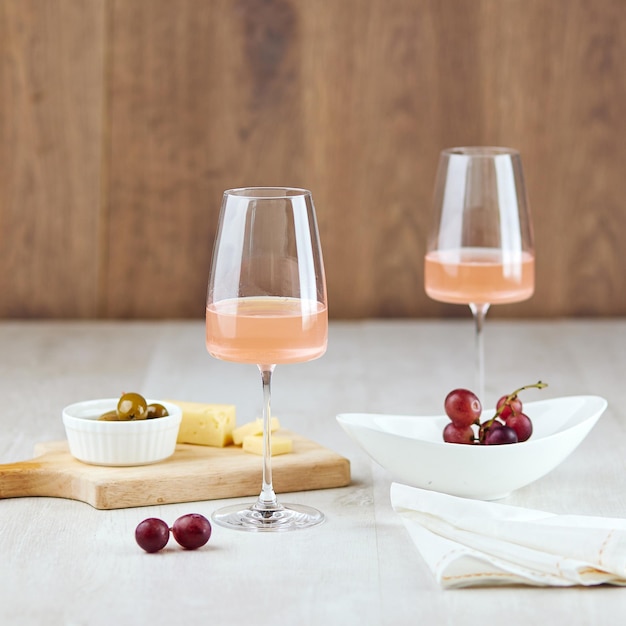 Bicchieri di vino rosato e snack per una cena romantica a tavola