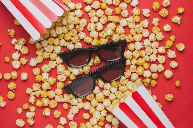 Glasses and popcorn on red top view