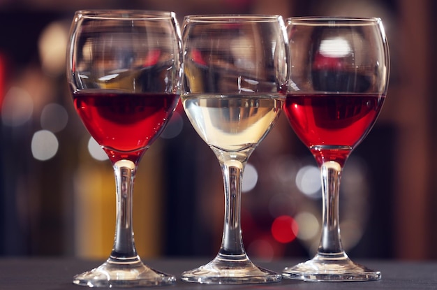 Photo glasses of red and white wine against blurred background