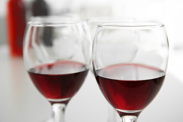 白いテーブルのクローズアップに赤ワインのグラス