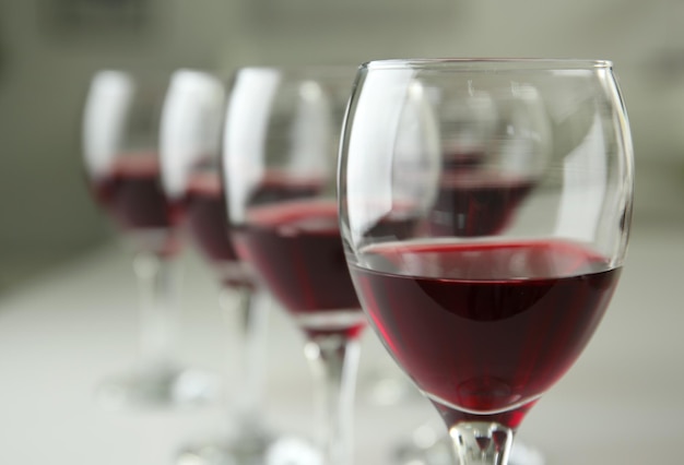 Glasses of red wine on white table closeup