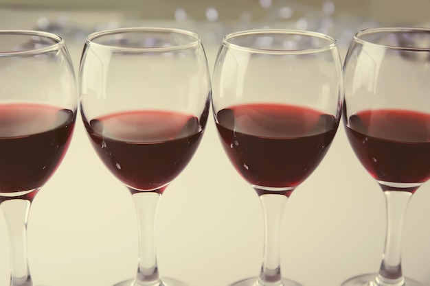 Glasses of red wine on white table closeup