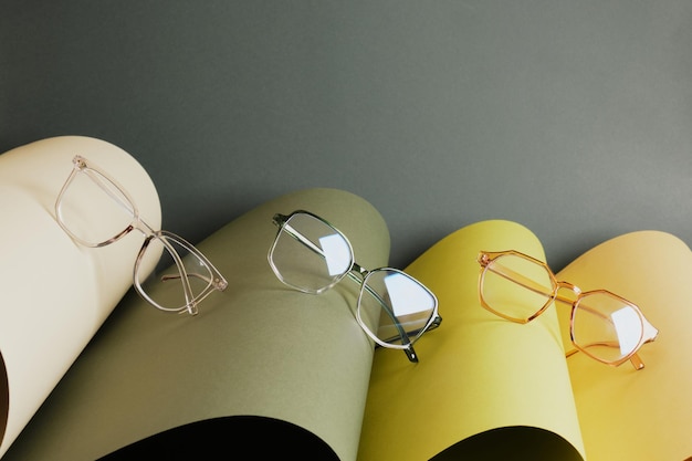 Glasses on rolled paper, geometric background, green colors, dark green background