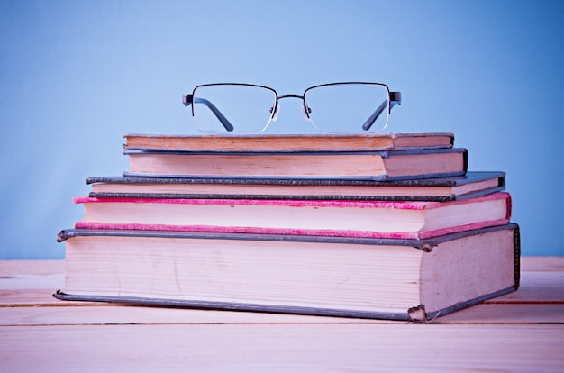 glasses on stack of book in vintage tone