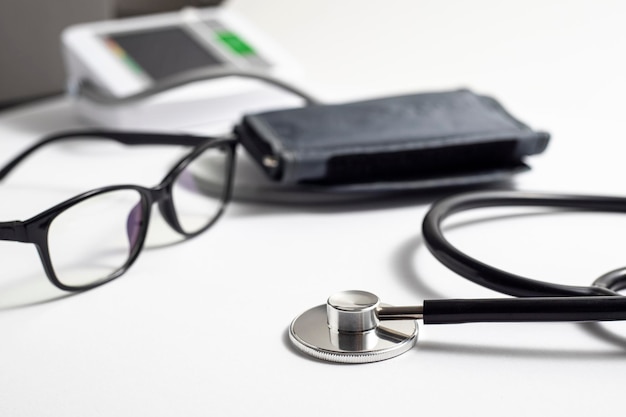 Glasses stethoscope pressure gauge on a white table