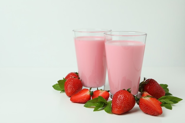 흰색 바탕에 딸기 밀크셰이크와 재료 잔