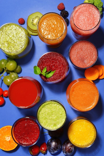 Foto bicchieri di gustoso succo fresco su sfondo blu