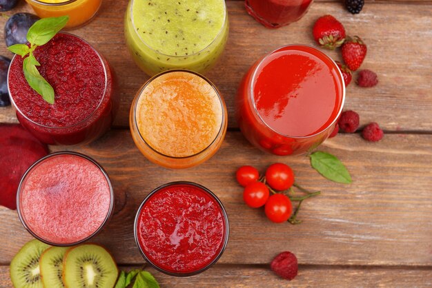 Glasses of tasty fresh juice on wooden table