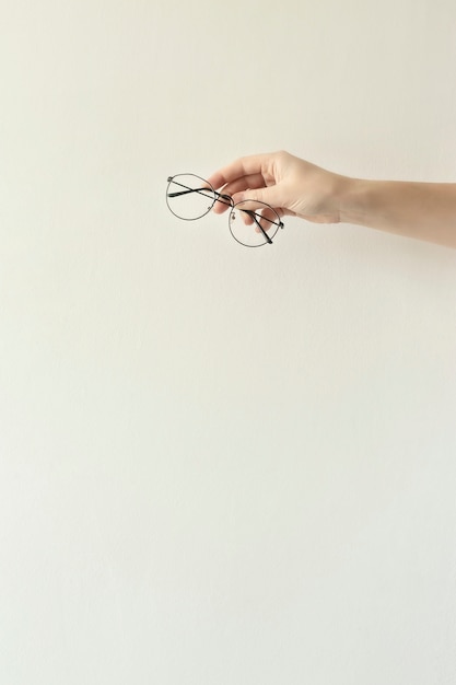 Glasses in a thin metal frame in the hands.