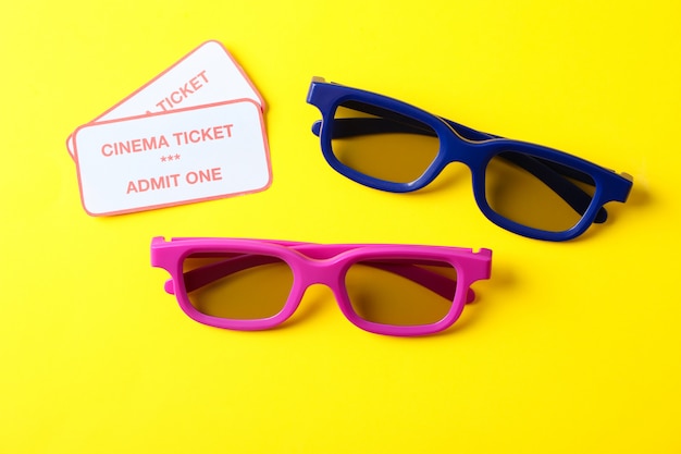 glasses and tickets on yellow background