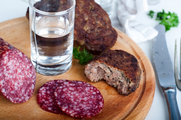 Glasses  vodka and board with sausage 