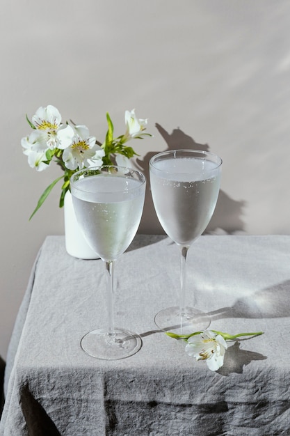 Glasses of water and flowers on table