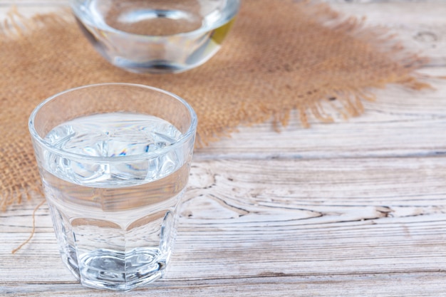 Glasses of water on wooden table.