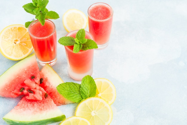 Glasses of watermelon mohito on blue table