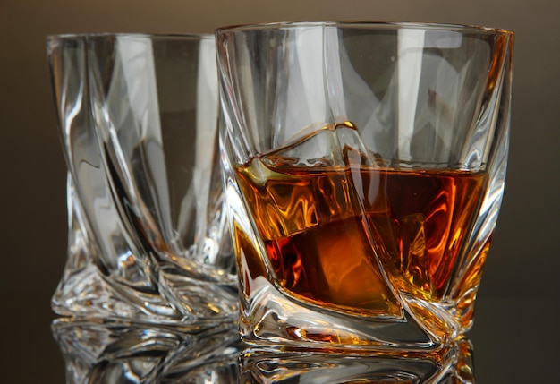 Glasses of whiskey on dark background