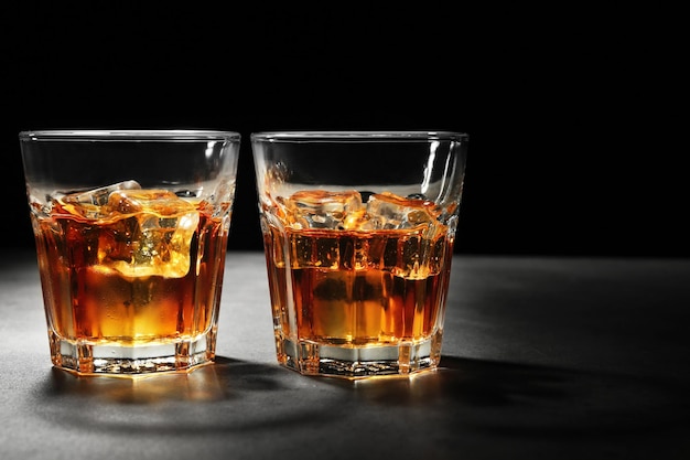 Glasses of whisky on dark background