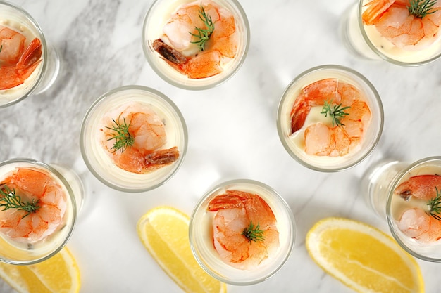 Glasses of white sauce and shrimps on table closeup