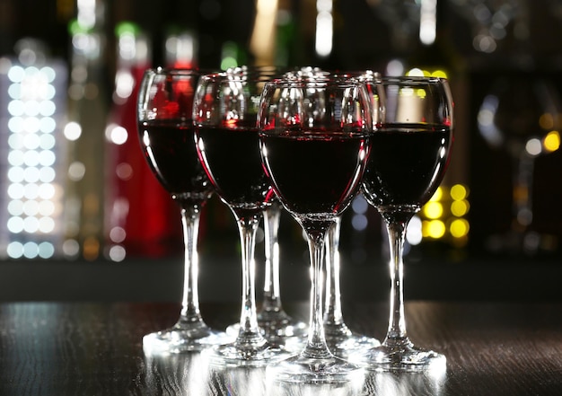 Glasses of wine with bar on background