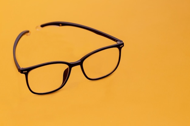 Glasses with black frames isolated on yellow background