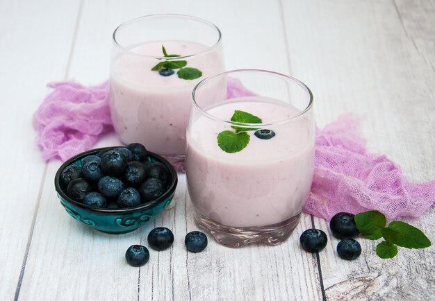 Photo glasses with blueberry yogurt on a table