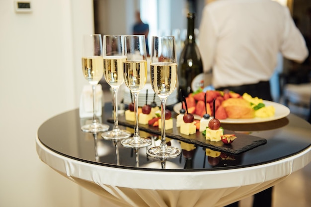 Bicchieri con champagne e frutta sul tavolo del buffet in un ristorante o nella hall dell'hotel