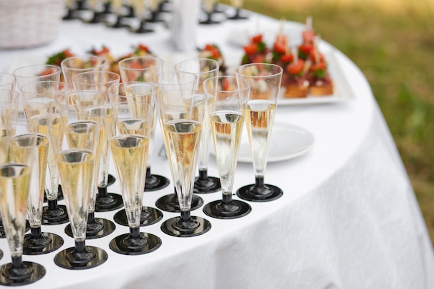 Glasses with champagne served on table near appetizers