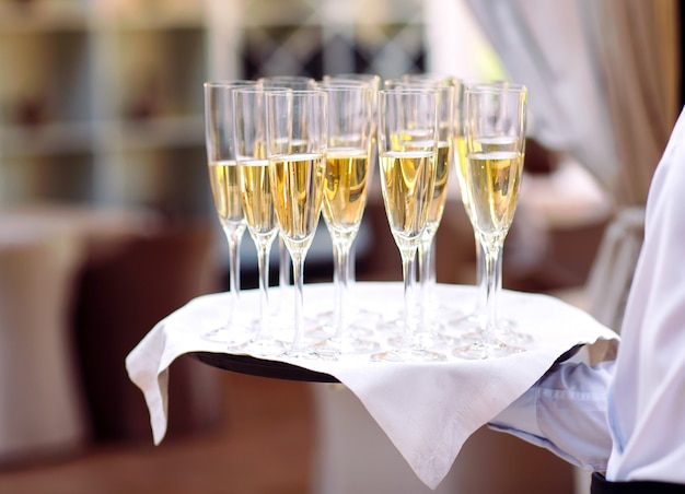 Glasses with champagne on a tray. Meeting the guests.