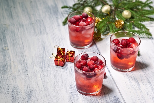 Vetri con succo di mirtillo rosso su legno bianco