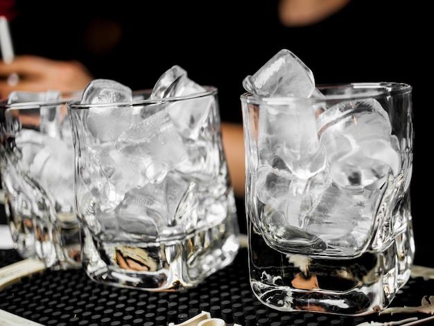 glasses with ice cubes are on the bar glasses with ice on a black background